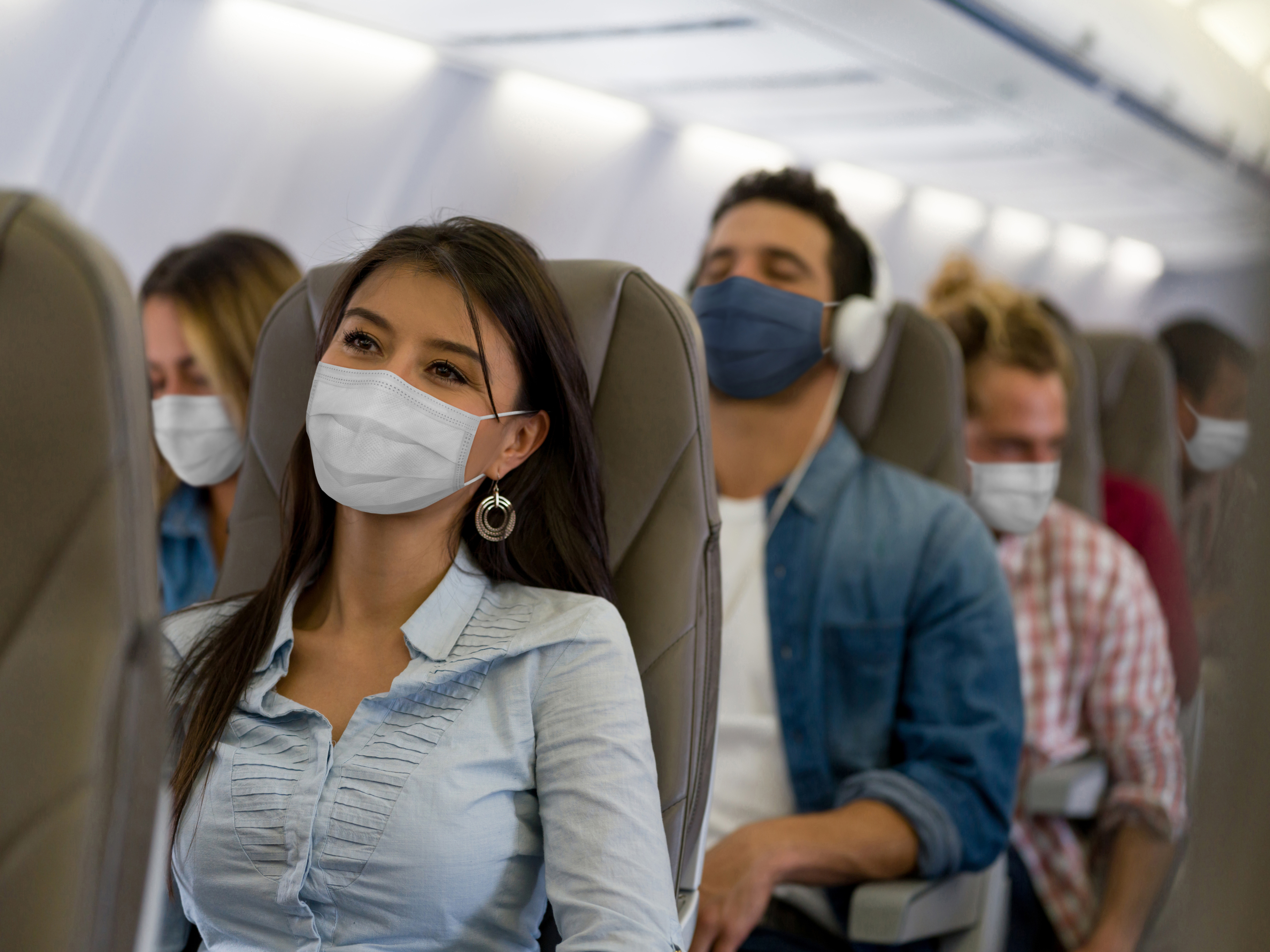 Passagiers met maskers op het vliegtuig