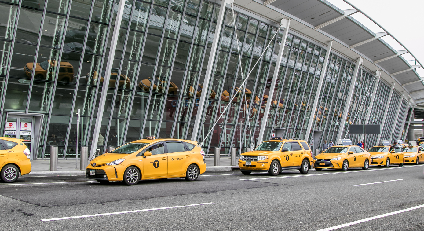 Verschillende geparkeerde Yellow Cabs in een rij buiten een luchthaven van New York.