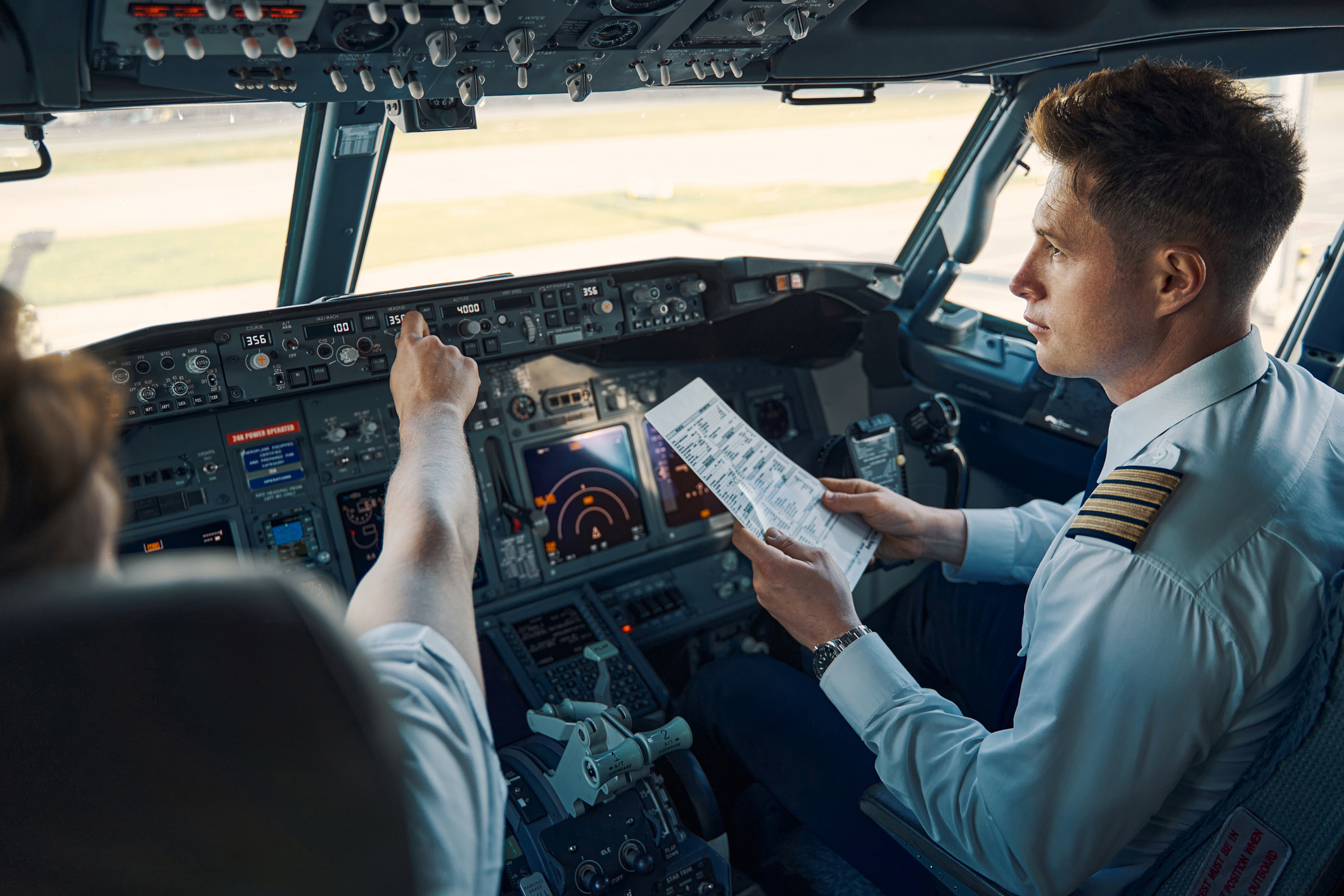 Piloten controleren de instrumenten en vluchtinformatie in de cockpit voordat ze opstijgen.