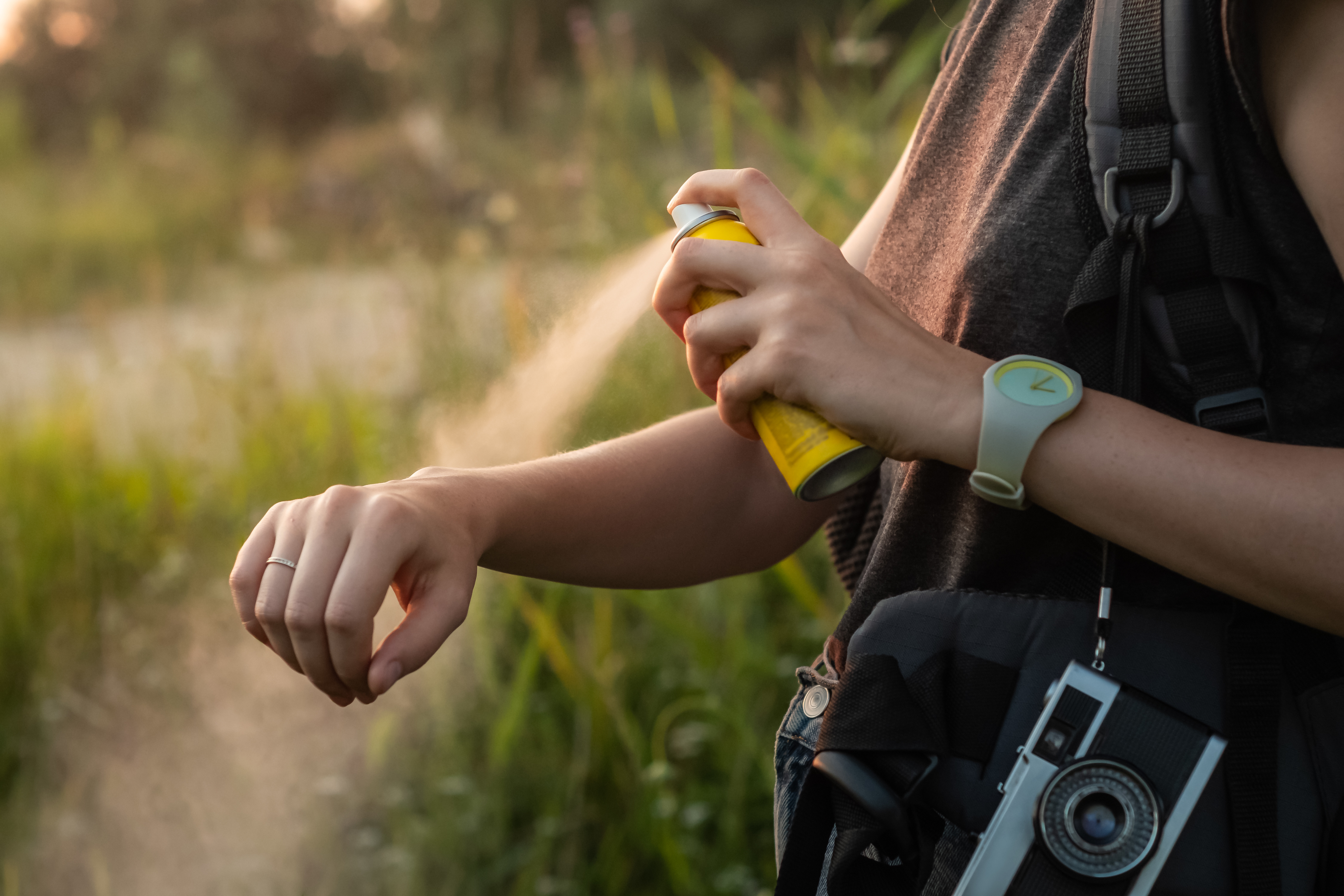 Spuit muggenspray op de arm buiten