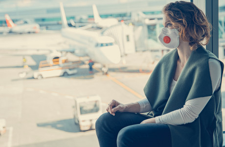 Vrouw met masker op de luchthaven
