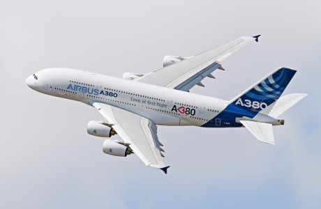 Een Airbus A380 in de lucht, het toestel draagt het opschrift "Love at first flight".