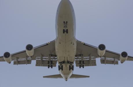 Een Boeing 747 van onderen met het landingsgestel uit.
