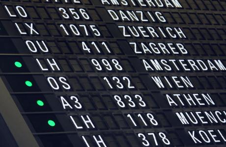 Vertrekbord waarop verschillende internationale vluchten worden weergegeven.